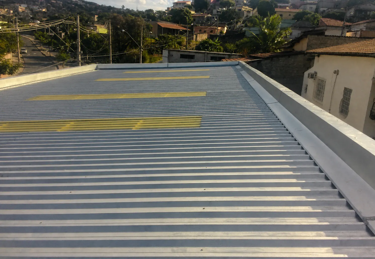 Cobertura metálica com telhas translúcidas em edifício residencial